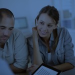 blue tinted man and woman talking to person holding a tablet